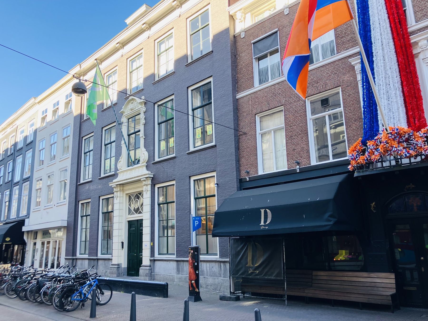D66 headquarters, a grey townhouse with the green D66 flag outside and campaign posters in the windows